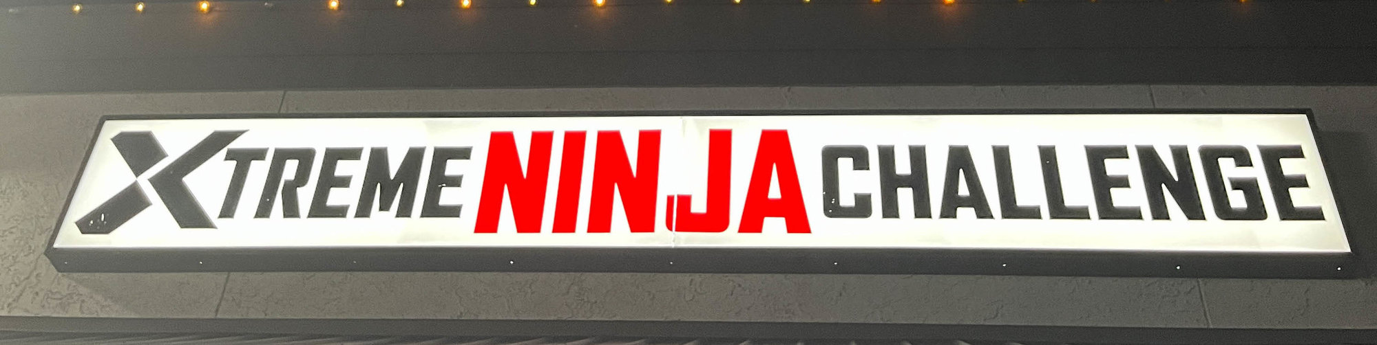 white sign with black and red text for xtreme ninja challenge